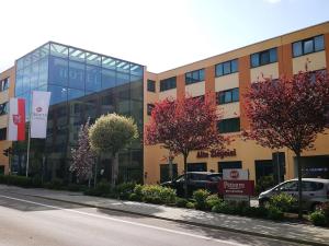 a hospital building with cars parked in front of it at Best Western Premier Novina Hotel Regensburg in Regensburg