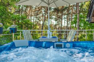 Ein Tisch und Stühle in einem Whirlpool mit einem Sonnenschirm in der Unterkunft Apartamenty Aparton in Ustka