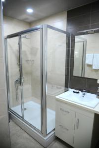 a bathroom with a glass shower and a sink at Metekhi Vista in Tbilisi City +38 photos