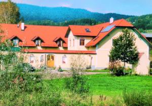 una casa grande con techo rojo en un campo en Biohof Höbarth en Sankt Martin