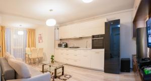 cocina y sala de estar con sofá y mesa en Pavel's Apartment, en Timisoara