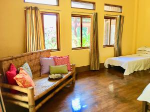 - un salon avec un banc et des oreillers dans l'établissement Dapitan Beach Villa, à Dapitan