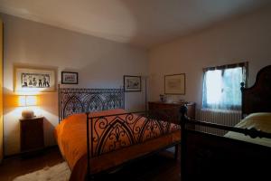 a bedroom with a bed with an orange bedspread at B&B Molino Del Gobbo in SantʼAgata Feltria