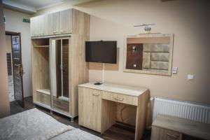 a bedroom with a bed and a tv on the wall at Hotel Centro Biznis 92 in Vinica