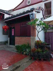 a house with a red door and a tree in front of it at Sunny's Home in Jincheng