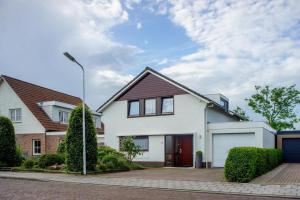 a white house with a garage and a street light at B&B de grote Zeearend in Aardenburg