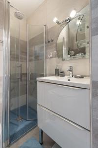 a white bathroom with a sink and a shower at Beautiful studio near sea (free parking) in Roquebrune-Cap-Martin
