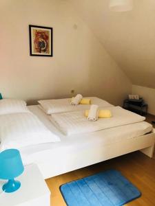 a large white bed in a room with a blue stool at Apartment Melody in Ivanić-Grad