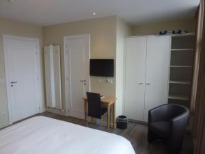 a bedroom with a bed and a desk and a chair at Hotel Sabot D'Or in Blankenberge