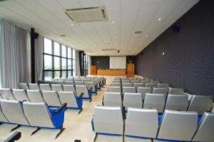 una sala de conferencias vacía con sillas blancas y una pantalla en Hotel Auditorio Santiago & Spa, en Lugo 37 fotos más