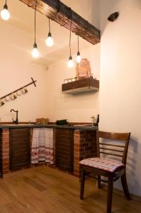 a kitchen with a chair and a counter with lights at Folkloric Loft-Ulița Românească in Sibiu