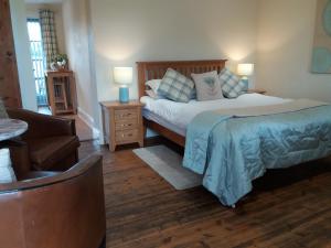 een slaapkamer met een bed, een bank en een stoel bij The Stables - Deer Park Farm in Solihull