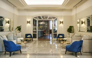 a lobby with couches and blue chairs at Bliston Suwan Park View - SHA Plus in Bangkok