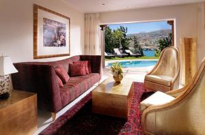 a living room with a couch and a pool at Out Of The Blue Resort & Spa in Agia Pelagia