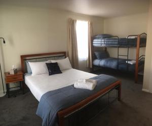 a bedroom with a bed and two bunk beds at 3ree- Spacious & Charming Apartment in Devonport