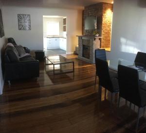 a living room with a table and a fireplace at 3ree- Spacious & Charming Apartment in Devonport