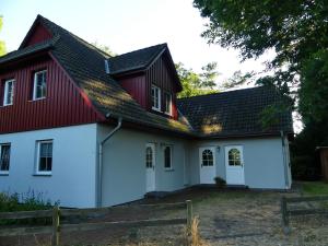 uma casa branca com um telhado vermelho em Ferienwohnungen Jagdhaus 6 em Wieck