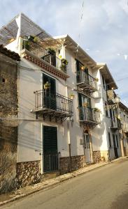 a white building with balconies and windows on a street at La Via del Carretto B&B in Capri Leone