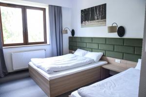 1 dormitorio con 2 camas y ventana en Lesna Perla Hostel de lux, en Marklowice
