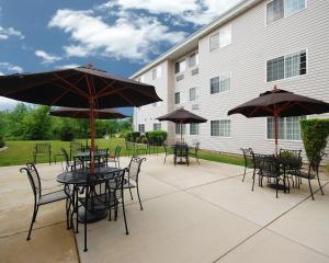a patio with tables and chairs with umbrellas at Hawthorn Suites By Wyndham Oak Creek/Milwaukee Airport in Milwaukee