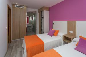 two beds in a room with purple and orange at Aparthotel Acuasol in Peniscola