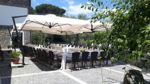 a table and chairs under a white umbrella at Il Casale Del Mirto in Vico Equense
