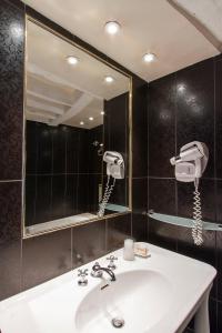 y baño con lavabo y espejo. en Hôtel Gaillon Opera, en París