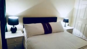 1 dormitorio con 1 cama con 2 lámparas en Enniscrone Apartment en Enniscrone