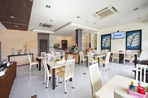 a restaurant with tables and chairs in a room at The Nice Krabi Hotel in Krabi