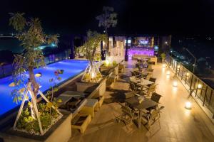 an outdoor restaurant with tables and a pool at night at Satoria Hotel Yogyakarta - CHSE Certified in Yogyakarta