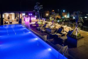 a swimming pool with lounge chairs and a city at night at Satoria Hotel Yogyakarta - CHSE Certified in Yogyakarta