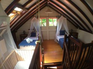 a attic room with two beds and a window at Villa des Amandiers in Les Anses-dʼArlets