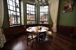 a dining room with a table and chairs and windows at Cupar Burgh Chambers in Cupar