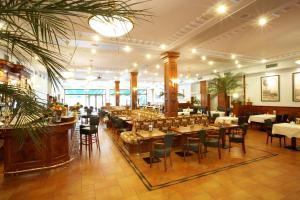 プラハにあるホテル アヴィオンのテーブルと椅子が備わるレストラン