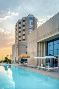 ein Hotel mit einem Swimmingpool vor einem Gebäude in der Unterkunft Hotel Baia Flaminia in Pesaro + 135 Fotos