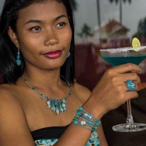 a woman holding a blue drink in a martini glass at Auberge de la Plage in Kep +39 photos