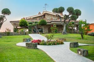 a house with a stone pathway in front of a yard at Le Rose in Nettuno