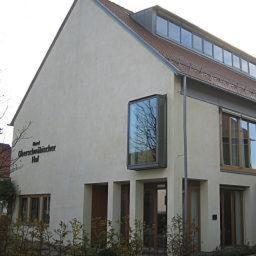 ein weißes Haus mit einem Baum im Fenster in der Unterkunft Hotel Oberschwaebischer Hof in Schwendi