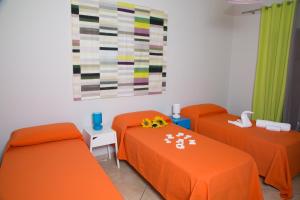 een oranje kamer met 2 bedden en een schilderij bij Stella Maris Case Vacanze in Balestrate