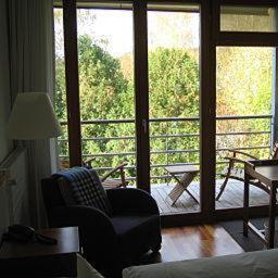 ein Wohnzimmer mit einem Stuhl und einem großen Fenster in der Unterkunft Hotel Oberschwaebischer Hof in Schwendi