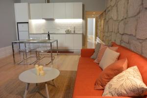 sala de estar con sofá naranja y mesa en Casa Paillard, by Flat in Porto en Oporto