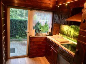 a kitchen with a sink and a large window at Holzhaus Trollblümchen am Wald und See in Neuruppin