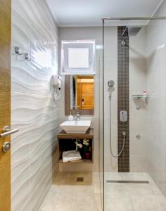 La salle de bains est pourvue d'une douche et d'un lavabo. dans l'établissement Villa Floris, à Mostar