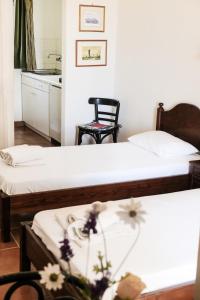 two beds in a room with a kitchen and a table at Corfu 9 Muses Ipsos in Ipsos