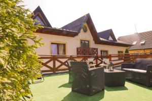 a house with a patio with chairs and a fence at Łapszańska Ostoja in Łapsze Niżne