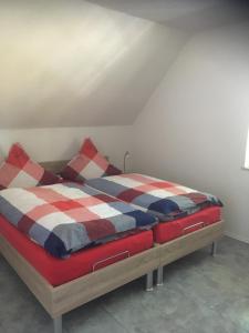 ヴェスターシュテーデにあるFeWo Haaseのベッドルーム1室(赤白と青の毛布付きのベッド1台付)
