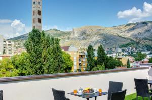 - un balcon avec une table et des chaises dans l'établissement Villa Floris, à Mostar