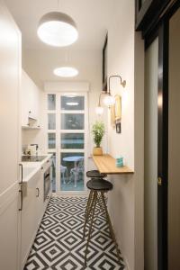 een keuken met een aanrecht en een kruk in een kamer bij Moderno y reformado apartamento al lado del Museo in Madrid