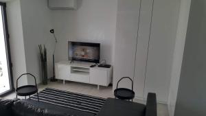 a living room with a couch and a television at Anatole - T3 - Moderne - Climatisé - 1er étage - Très grande terrasse - Vue magnifique et dégagée in Saint-Mandrier-sur-Mer