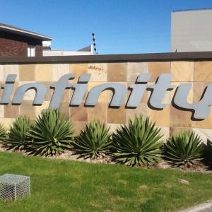 a sign on the side of a building with plants at 101Infinity in Bloubergstrand
